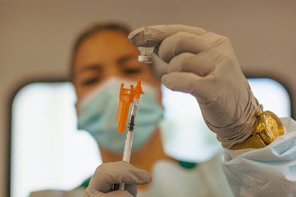 A health care worker prepares to administer the Pfizer-BioNTech vaccine last month in Miami.